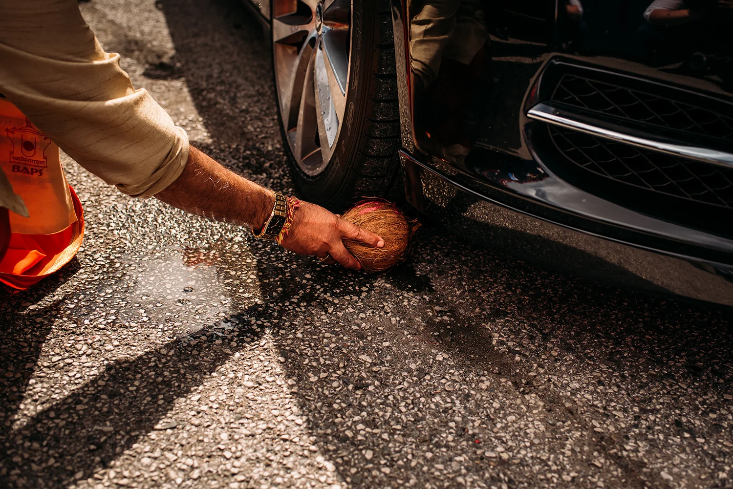 a coconut being placed under the car tyre