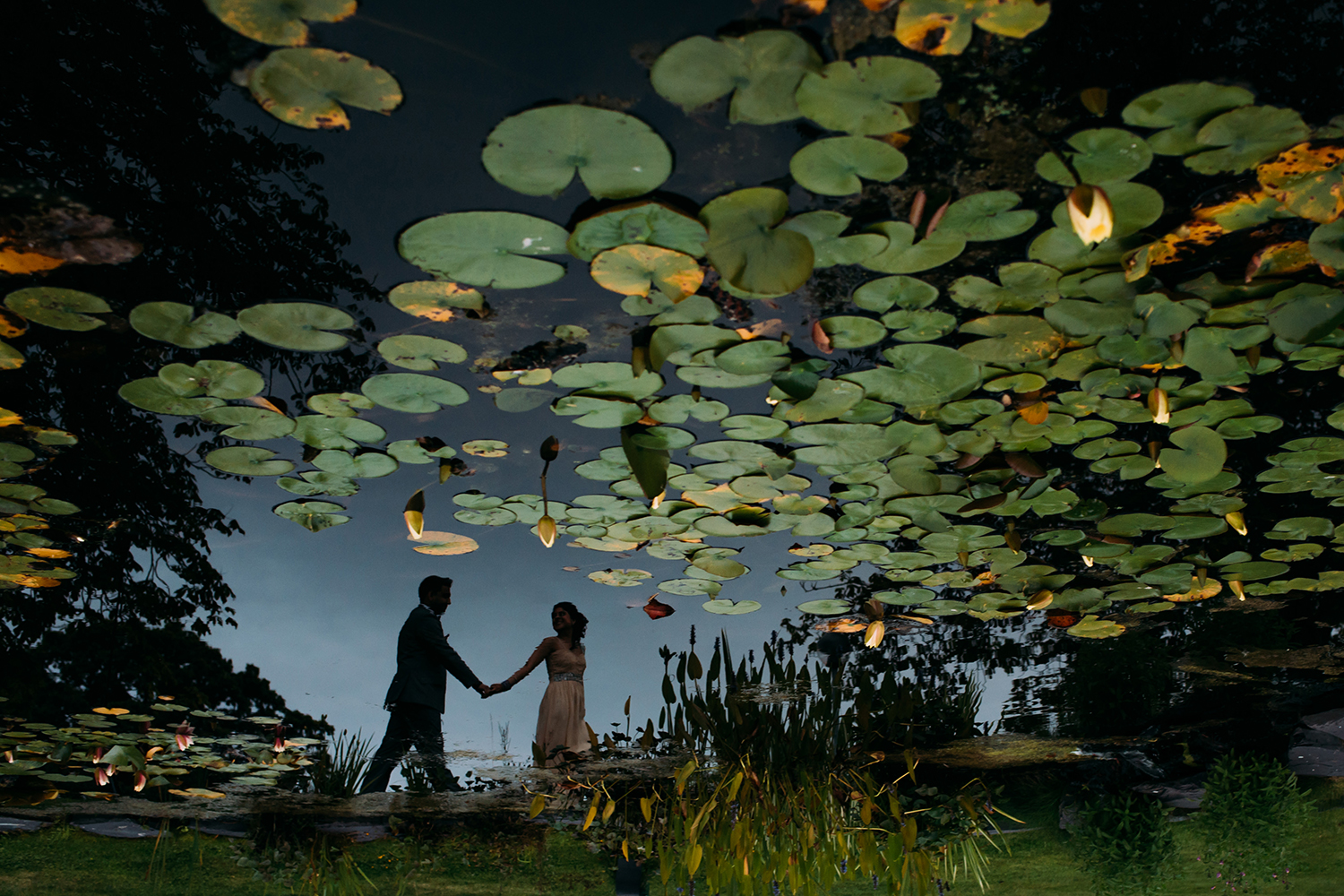  reflection of bride and groom in a pond 