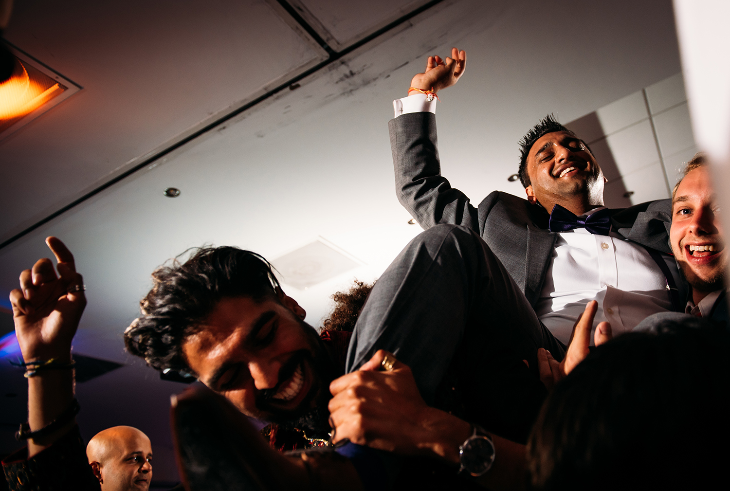  action photo of groom being lifted on the dancefloor 