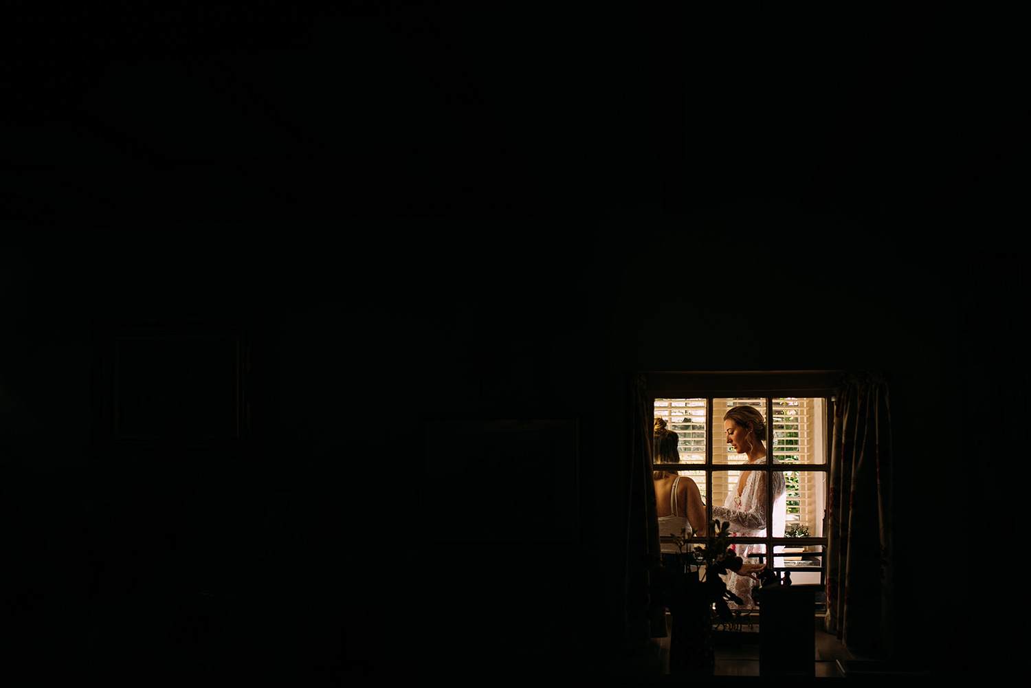  black image with a small frame of light in the bottom right corner of the bride in another room 