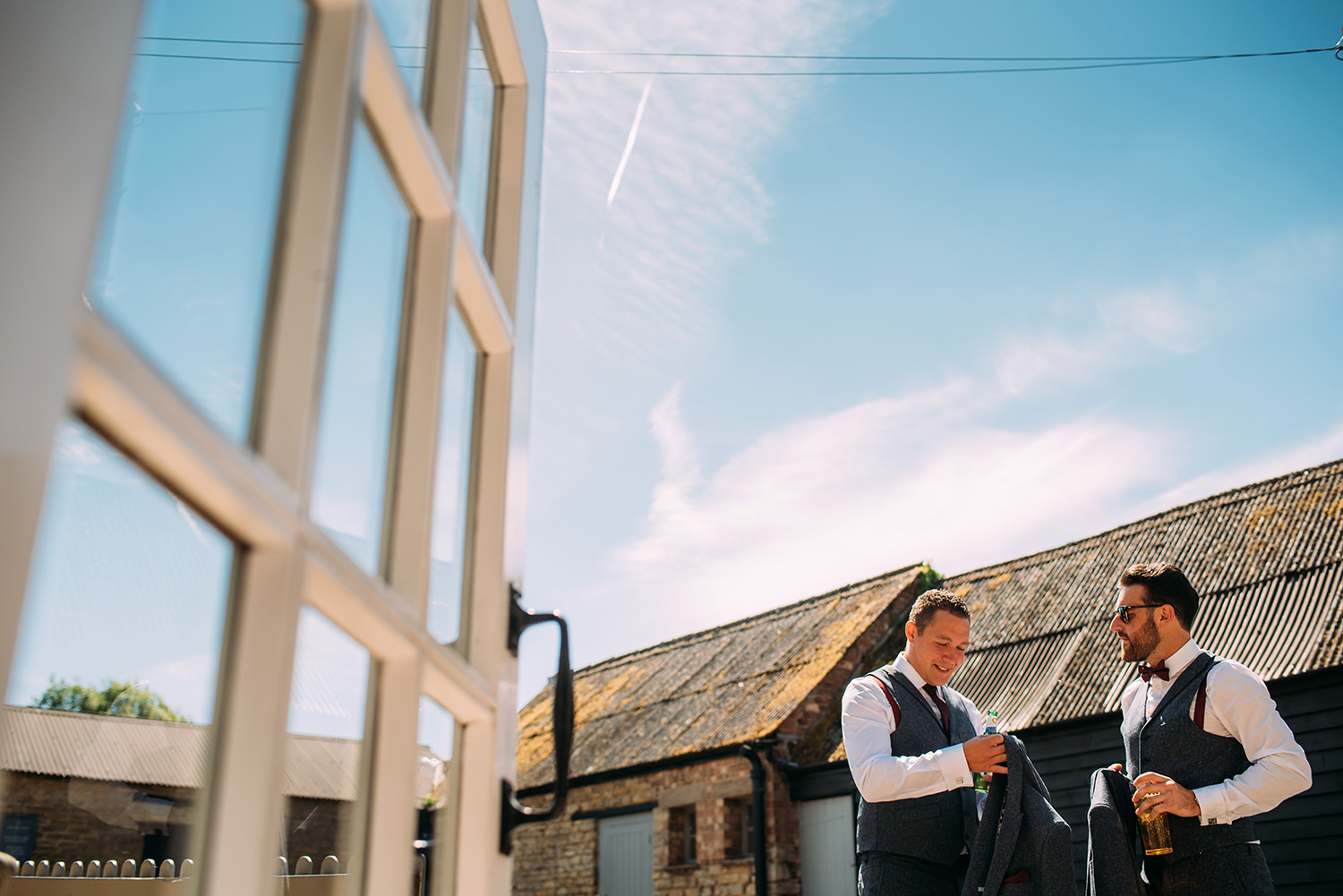  photo of the groom and best man out side from the inside 