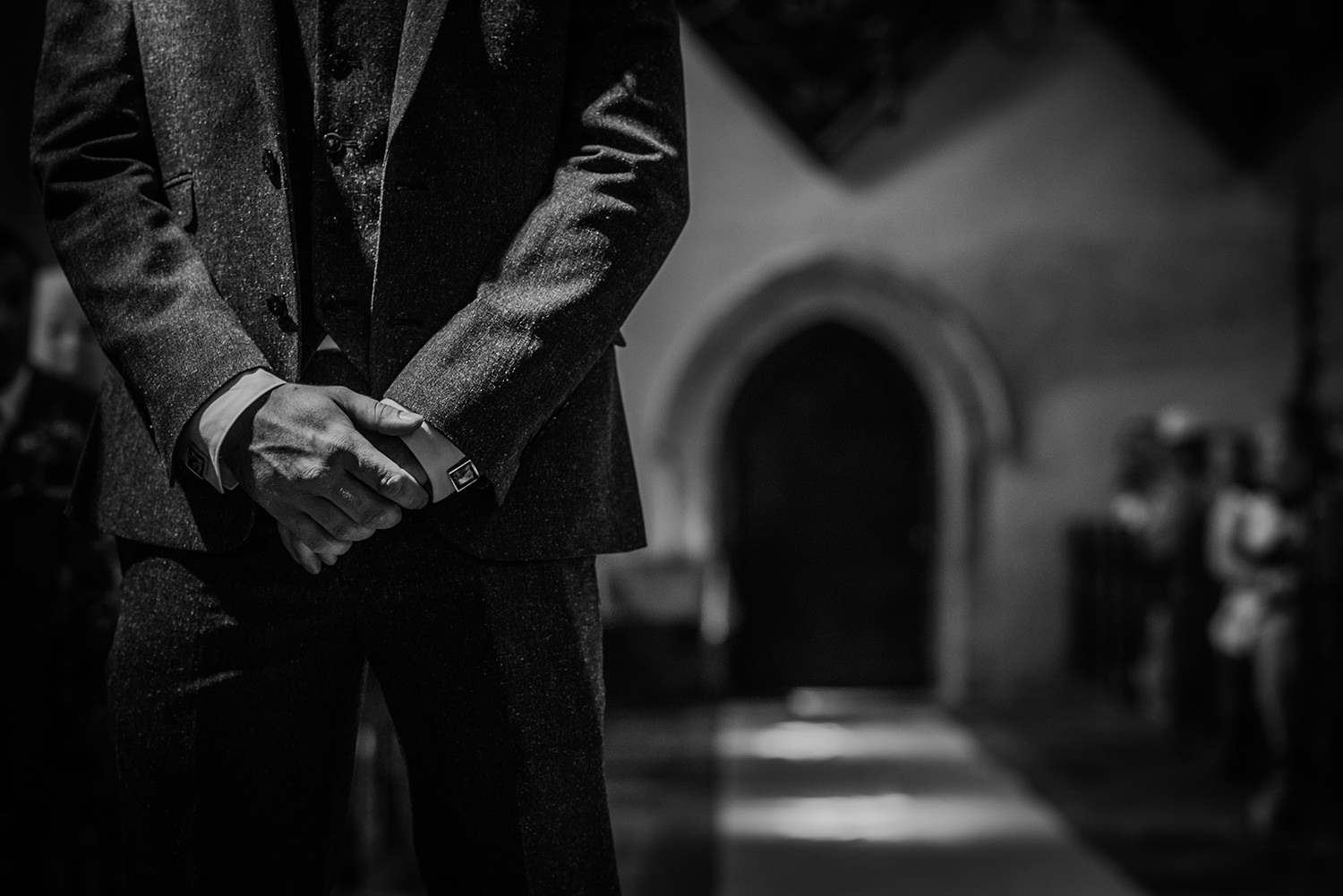  bw photo of the groom’s hands as he waits 