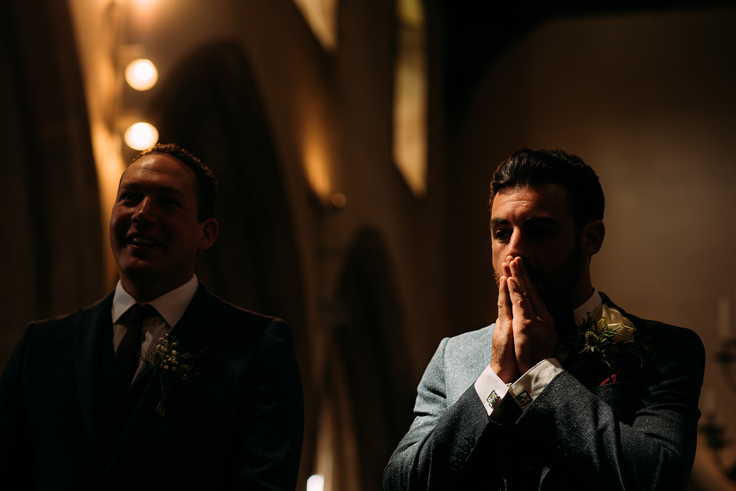  groom rubs his face nervously in strong light 