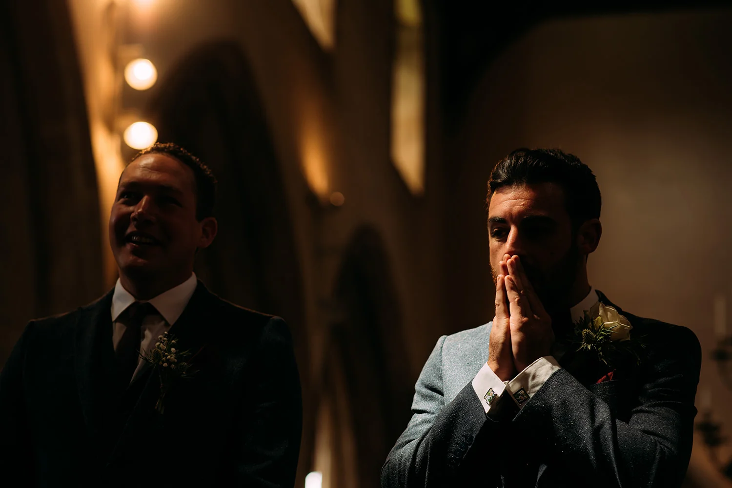 groom rubs his face nervously in strong light
