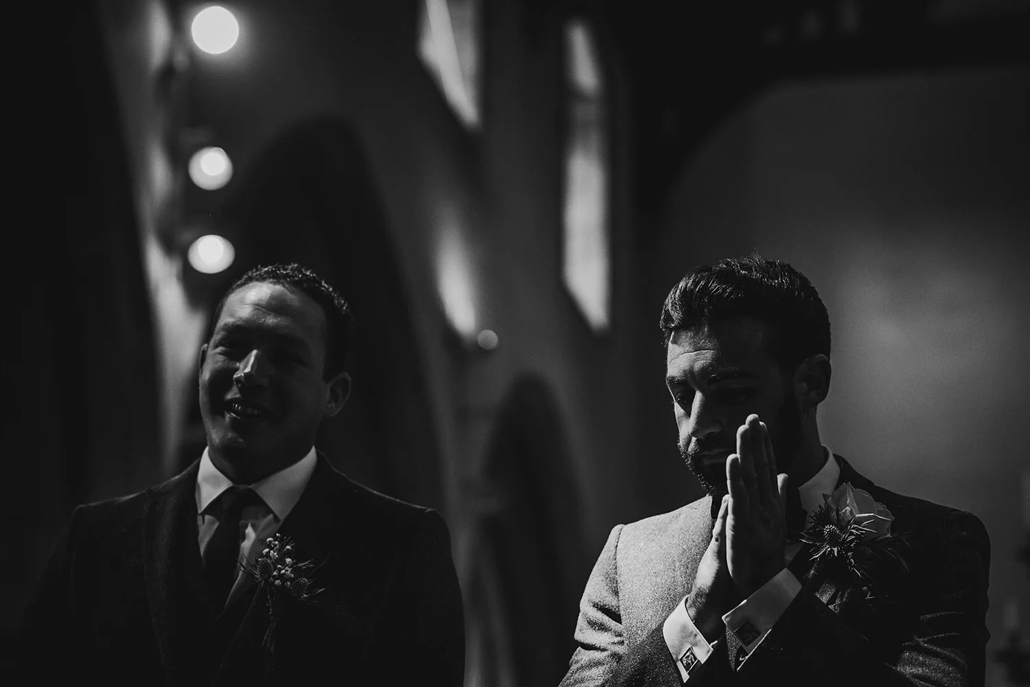 bw photo. Groom rubs hands nervously in strong light