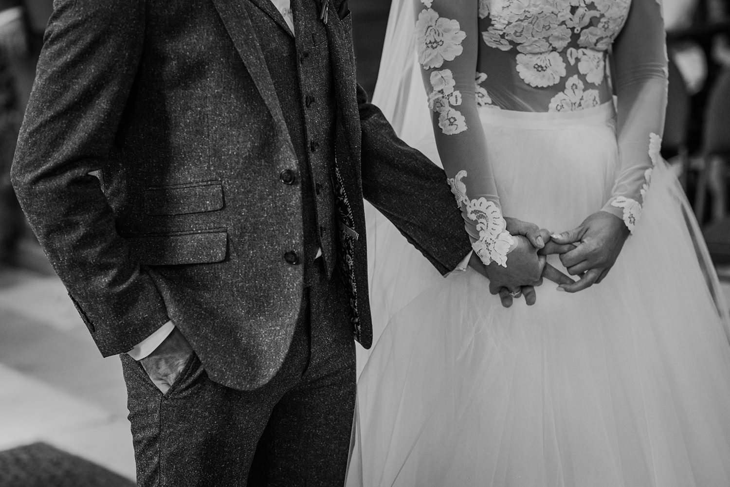  bw photo of bride and groom holding hands 