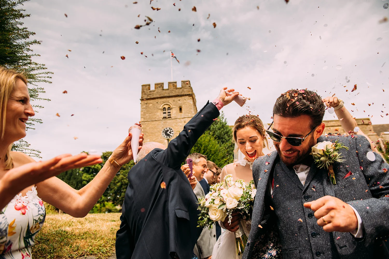 bride and groom leave under confetti