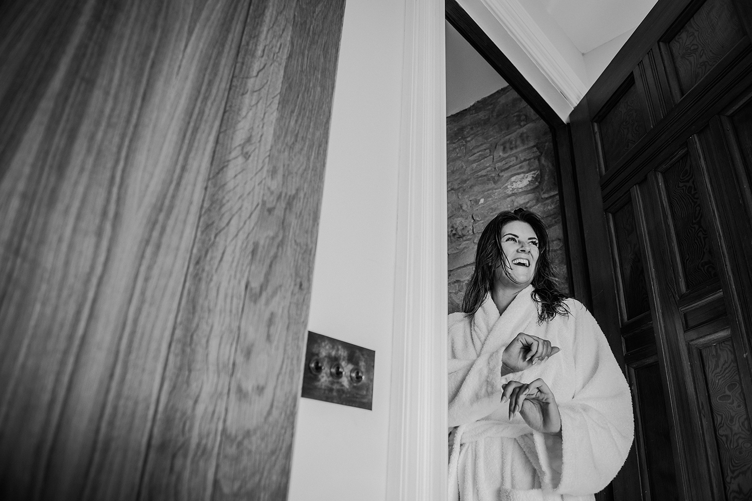 Bw photo of bridesmaid laughing in the doorway