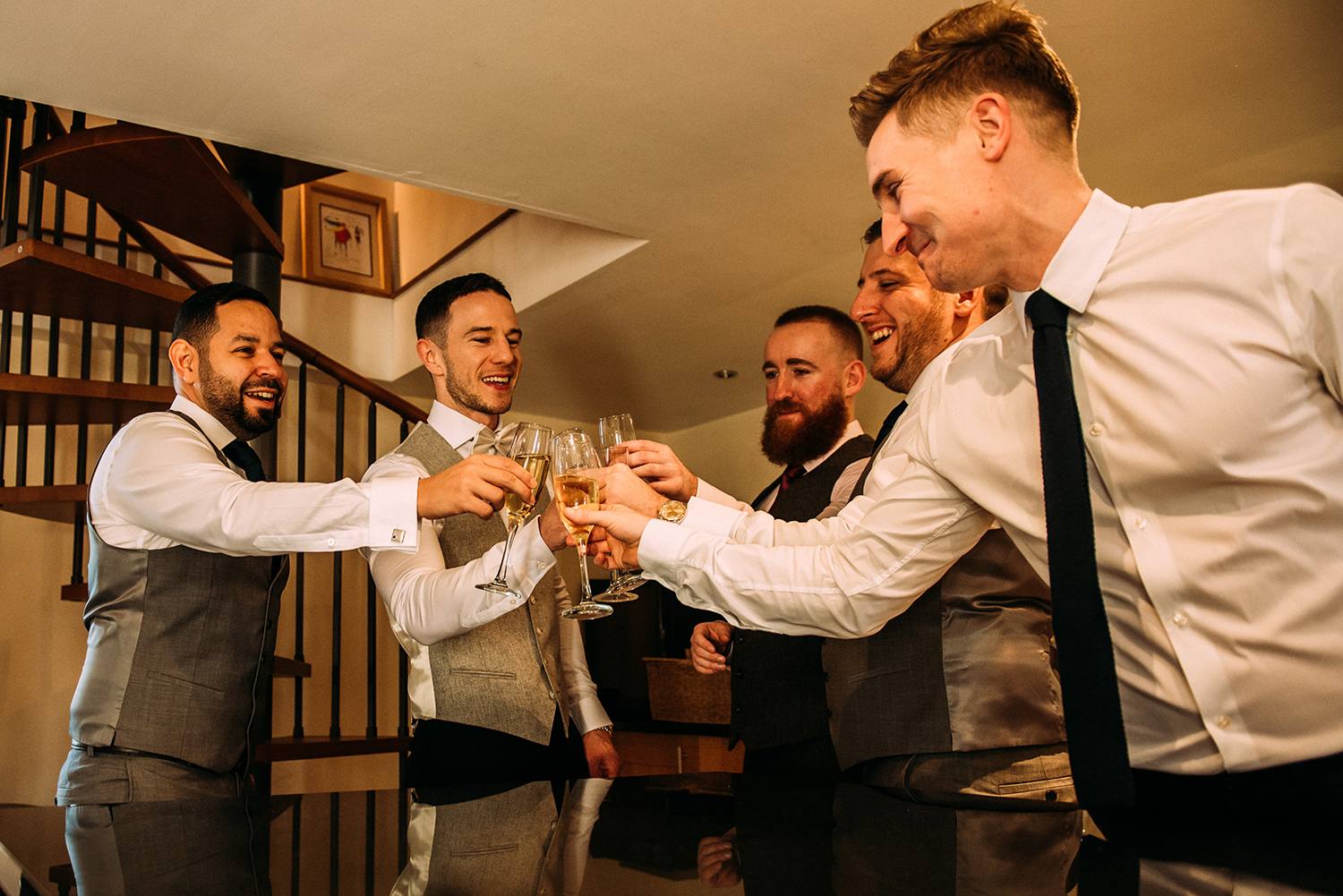 the guys ‘cheers’ their glasses in the kitchen