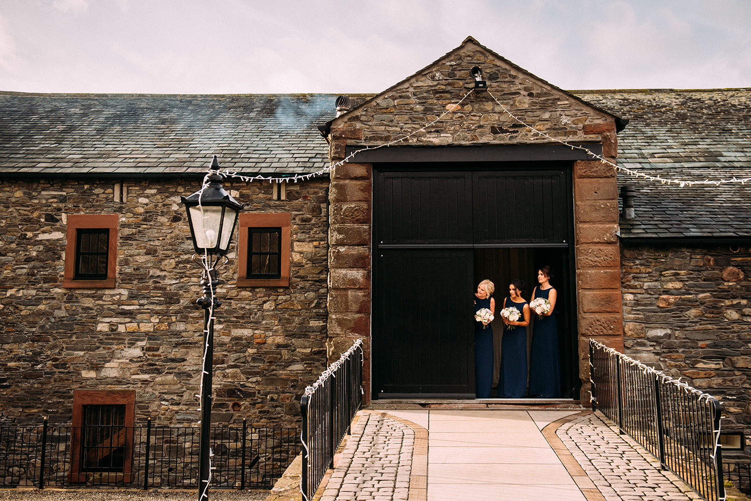 bridesmaids peek out of new house farm door