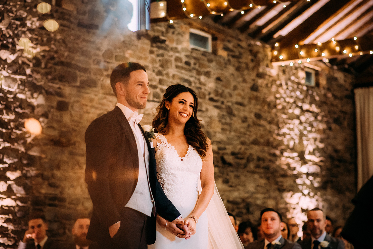 bride and groom smile during the readings