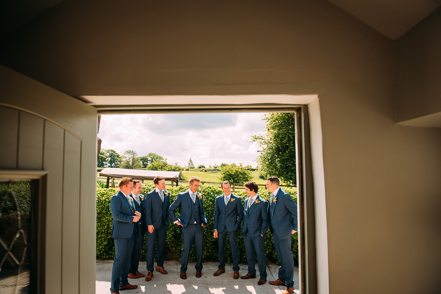 groom and groomsmen laughing in the doorway