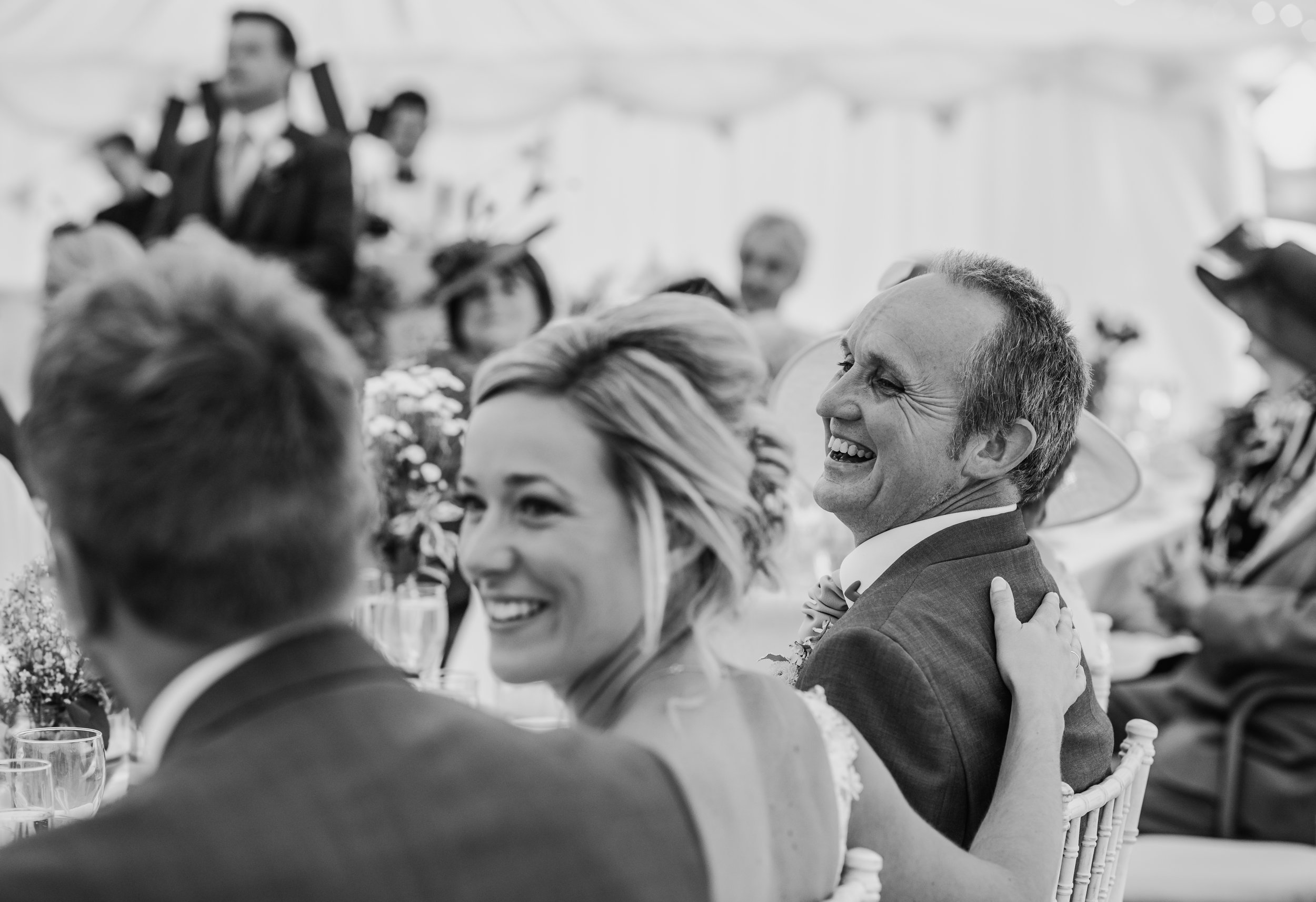 bw photo. Brides hand on her fathers back as he laughs