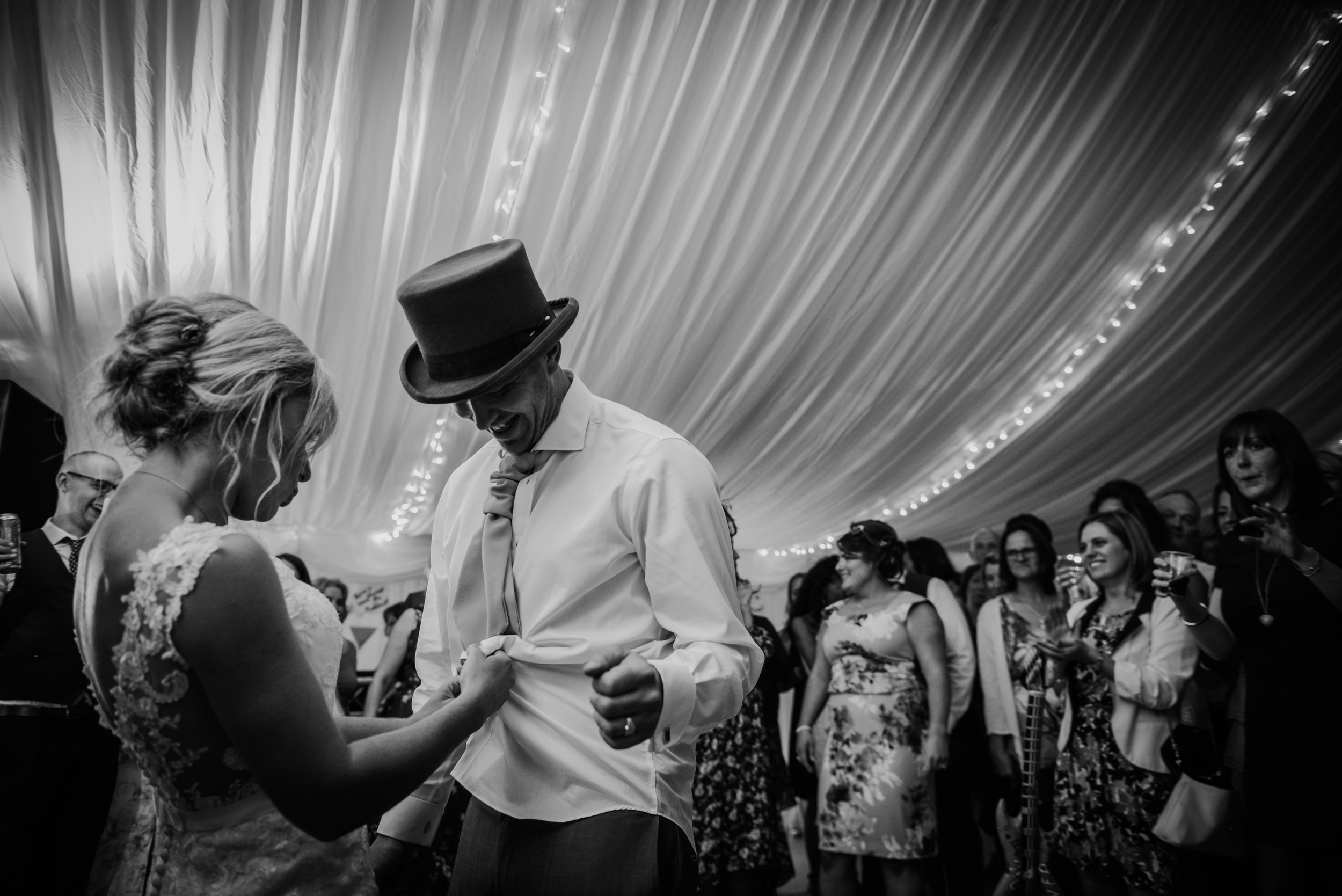 bw photo of the bride unbuttoning the grooms shirt