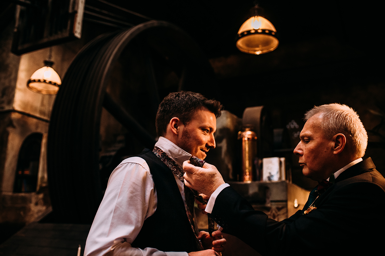 Groom having his tie done by his father