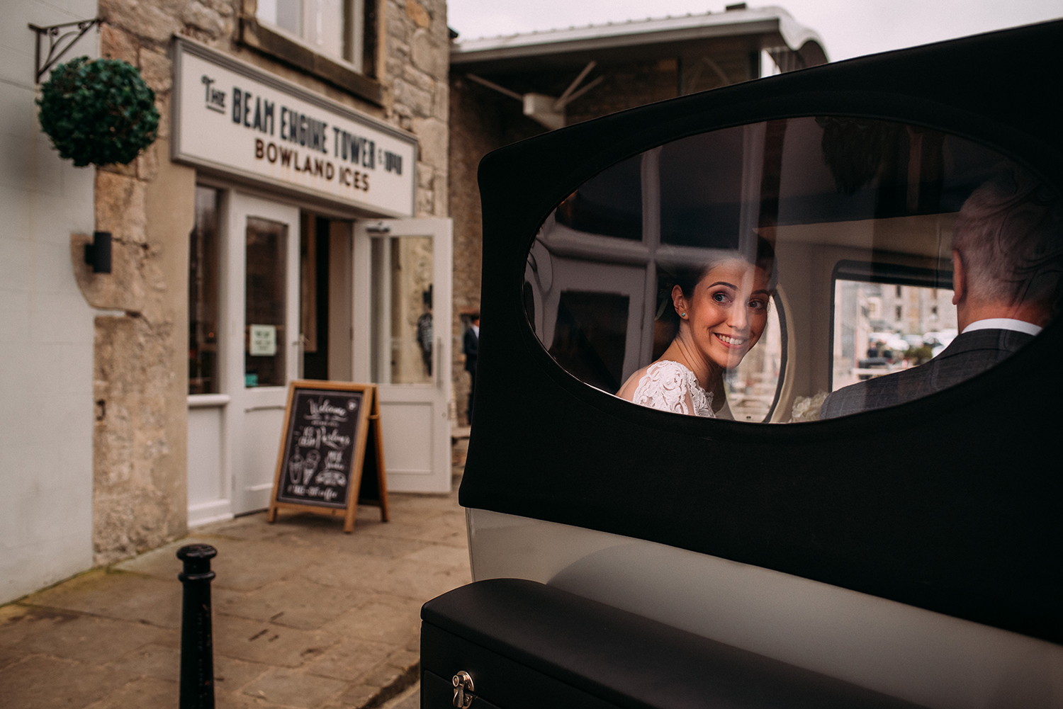 Bride looking over her shoulder out of the car window