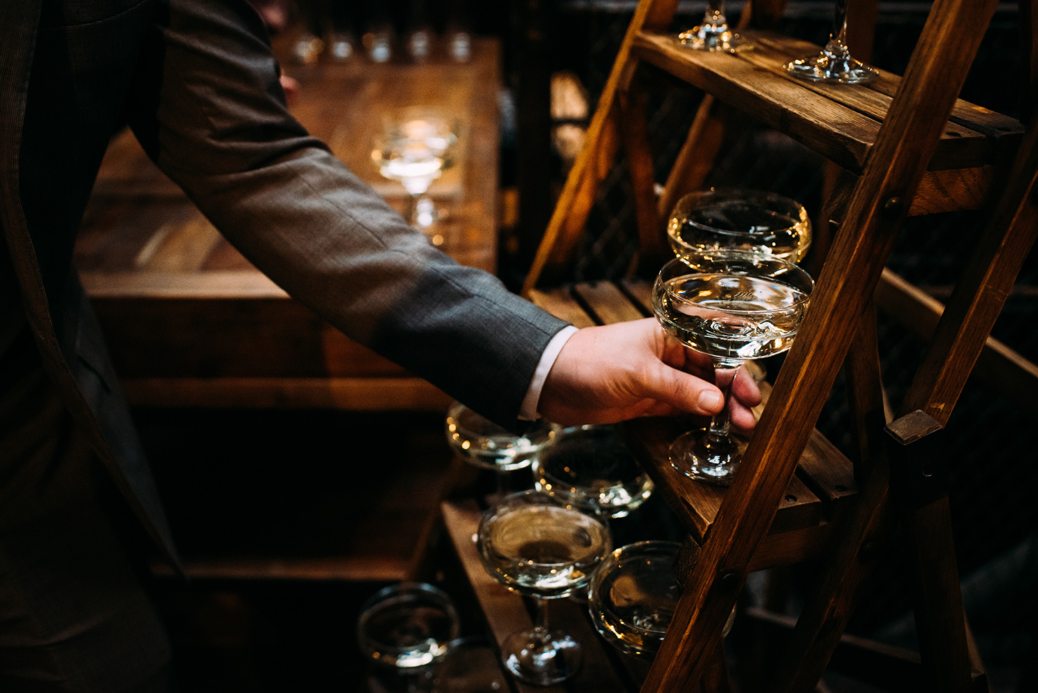 a hand grabbing a glass of champagne