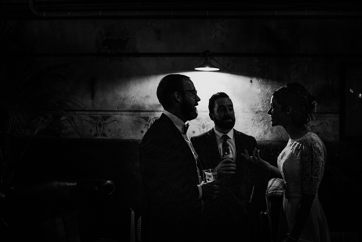 bw silhouette of guests under a lamp