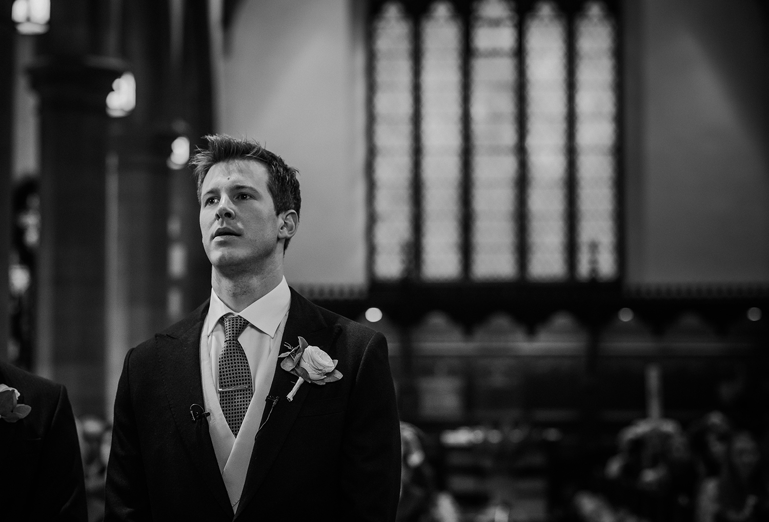 BW photo of nervous groom in church