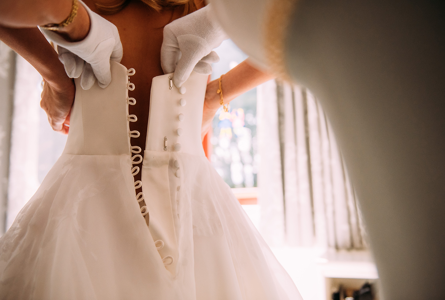  mother fastening the brides dress 