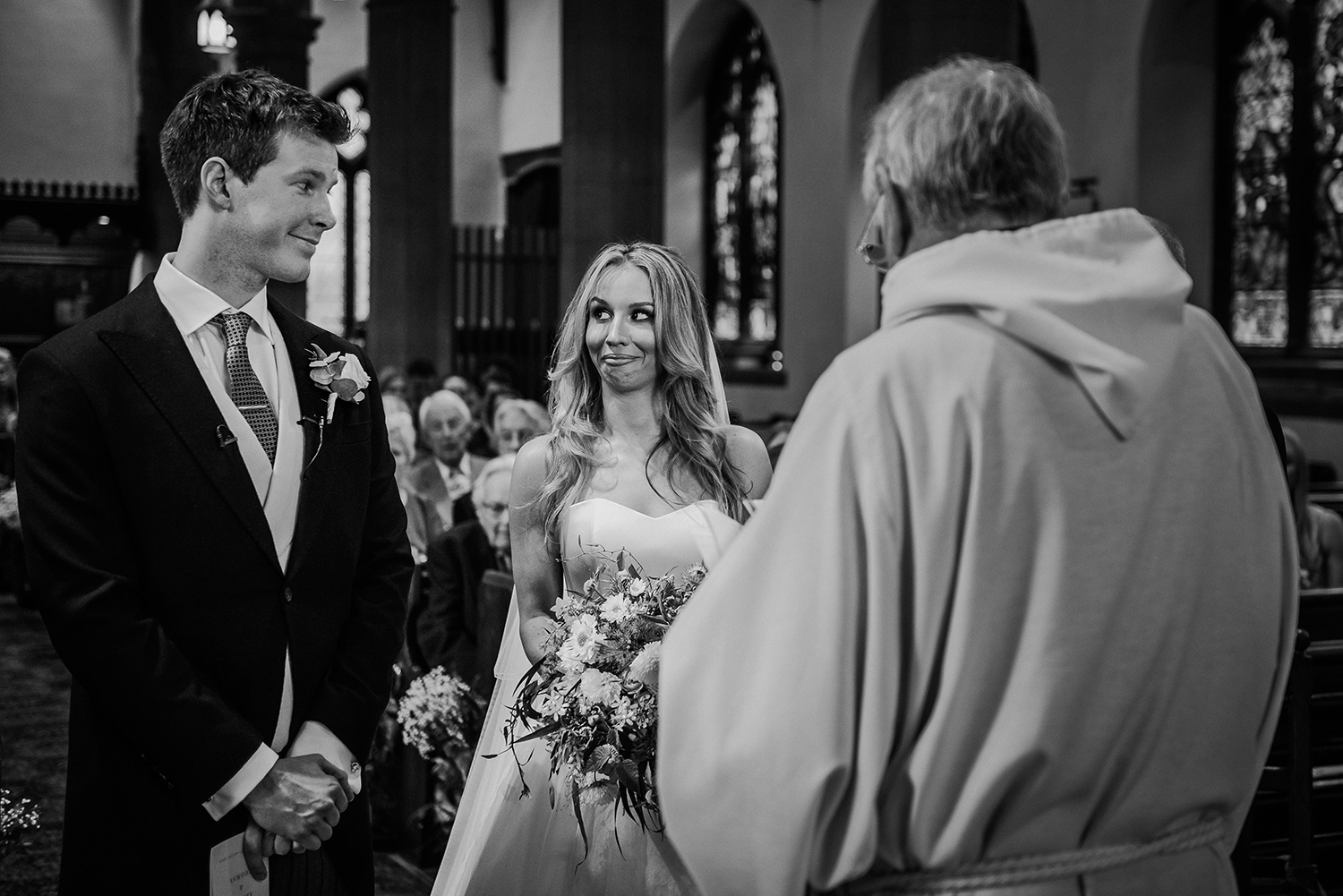 BW photo of bride and groom pulling funny faces at each other