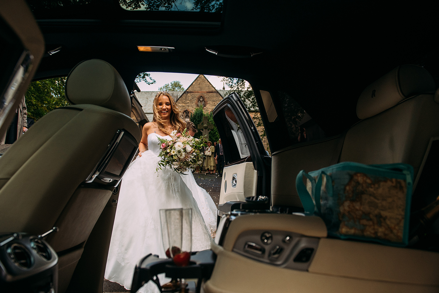  bride and groom getting into car 