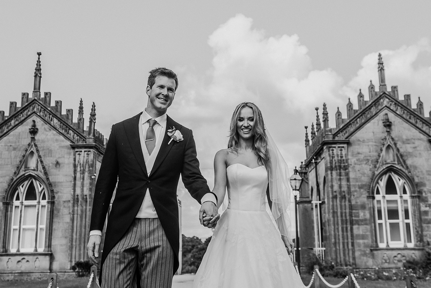 BW photo of bride and groom at the venue gates