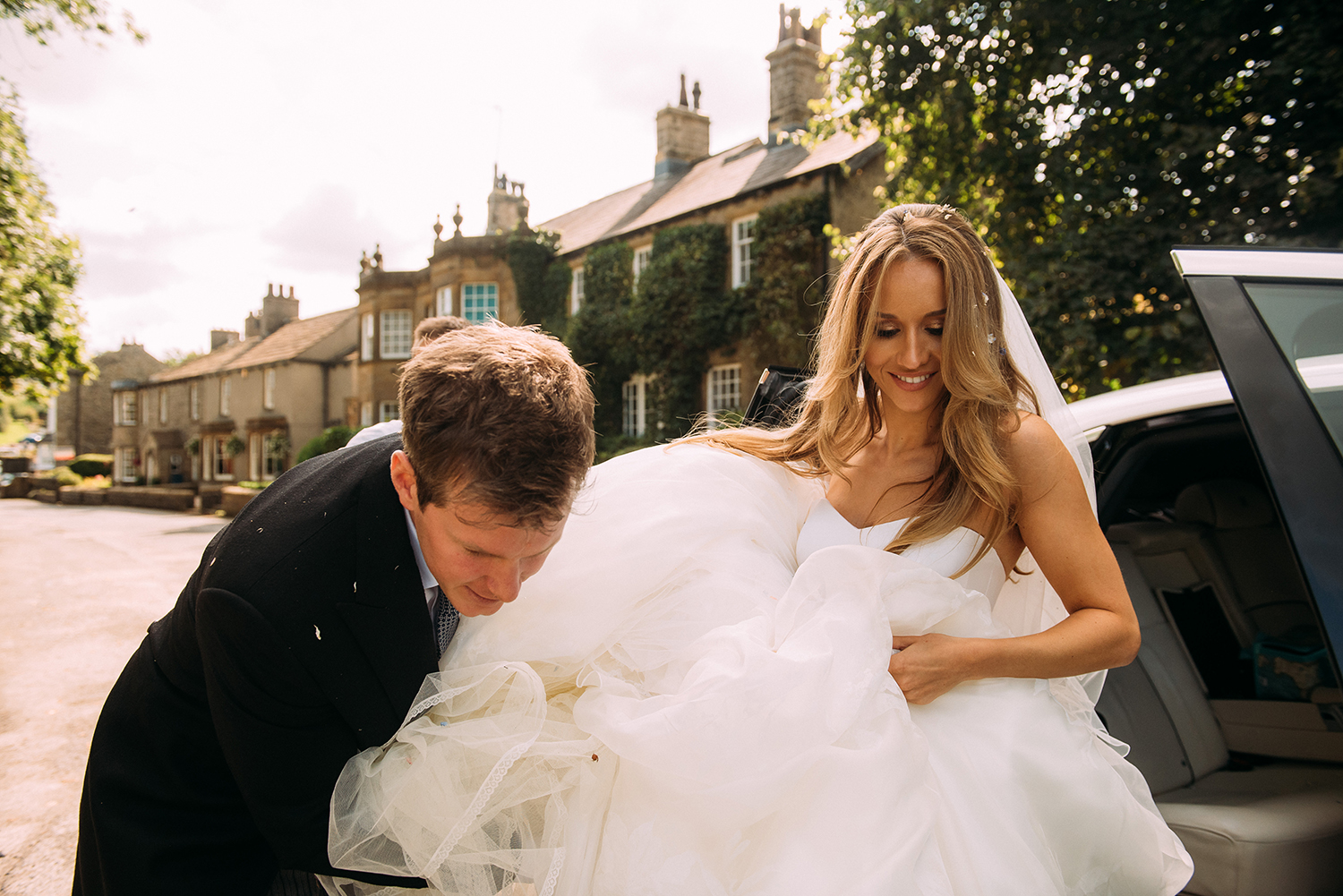 groom helping bride out of the car