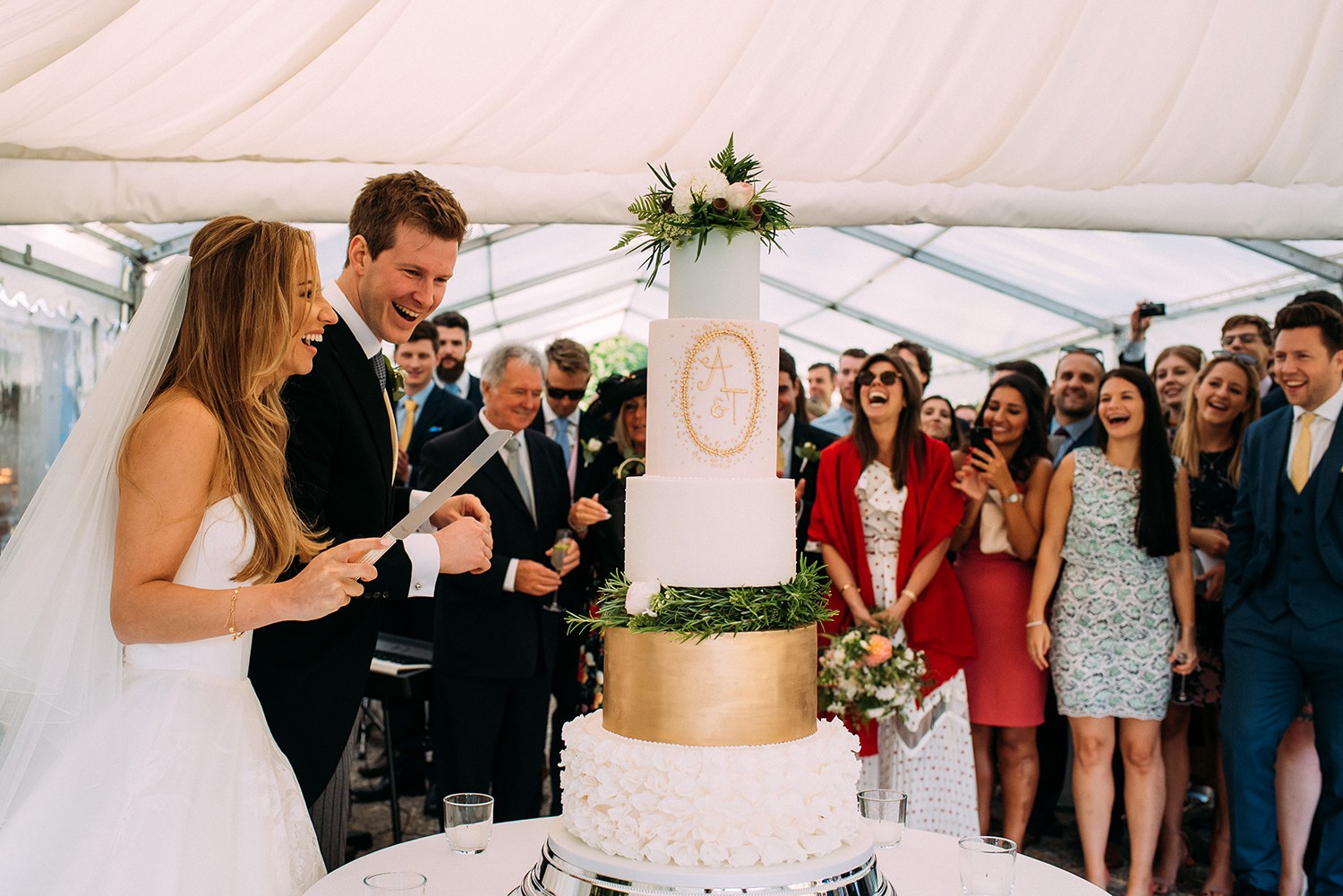 guest look on and laugh as they cut the cake
