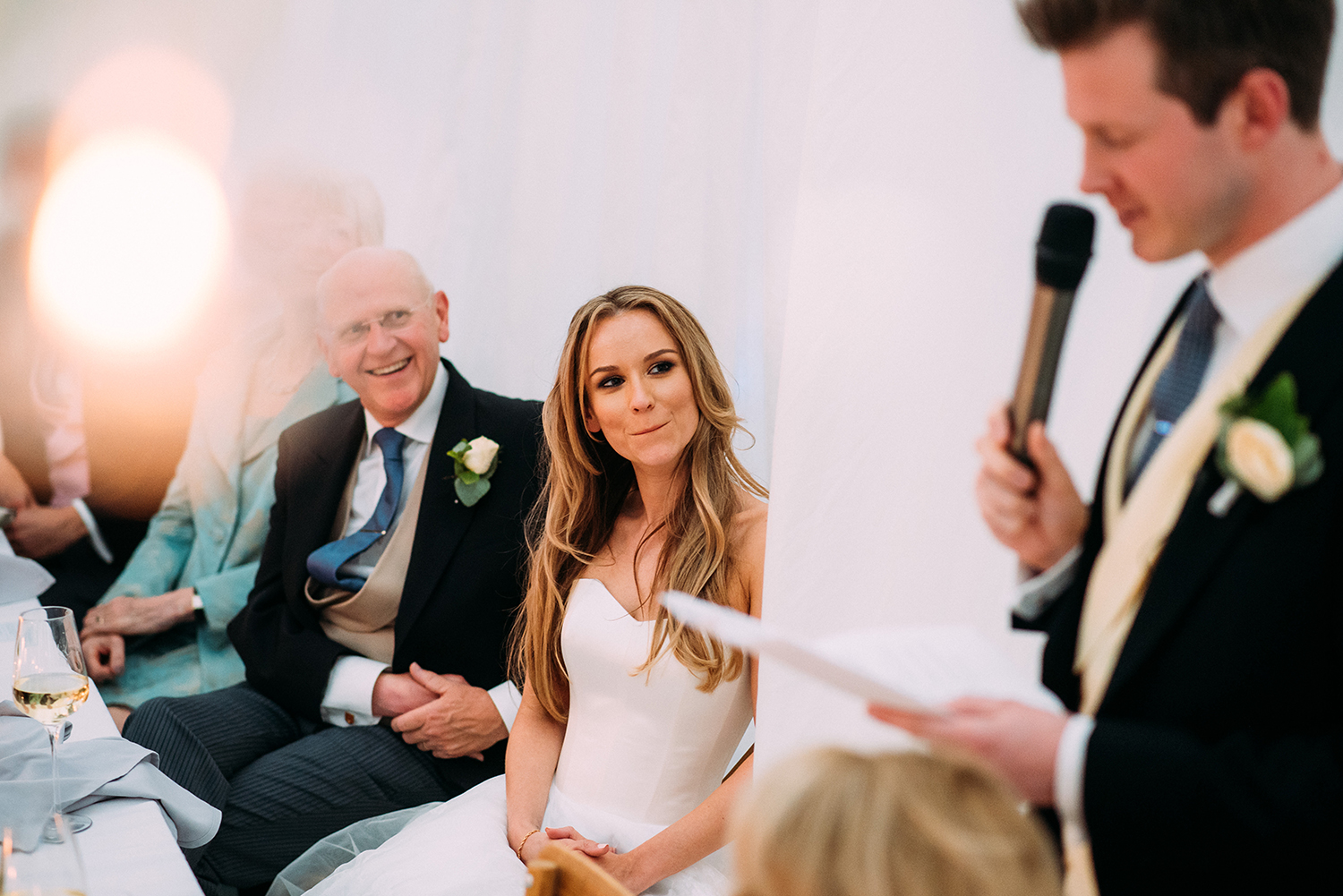 bride looking at groom during his speech