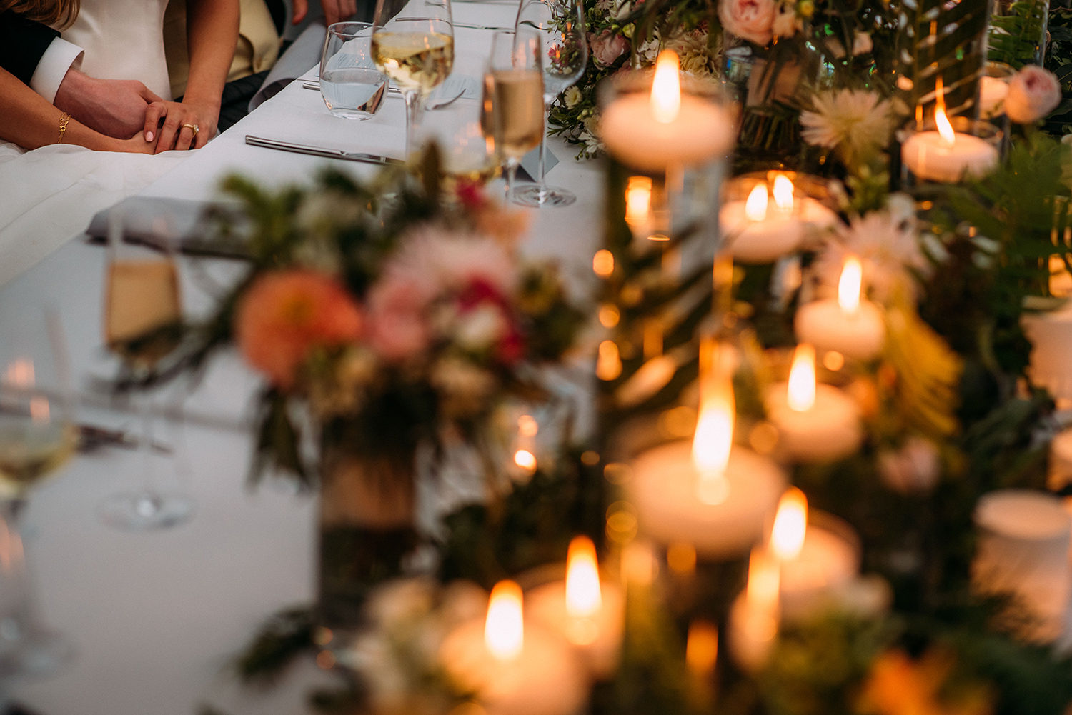  the table full of candles and B&amp;G holding hands in the corner 