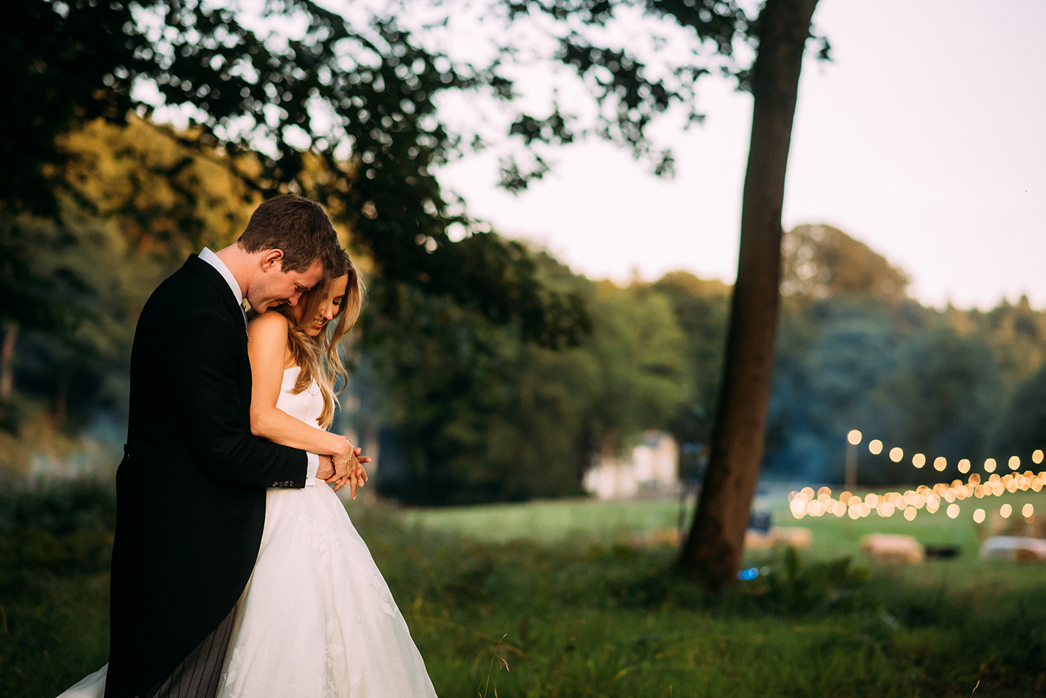  bride and groom cuddle with the venue in the background 