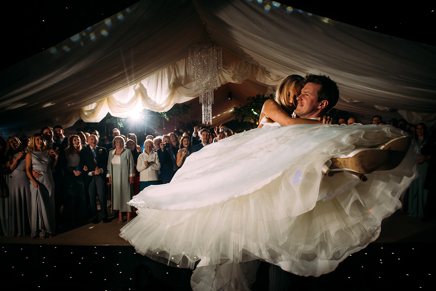groom lifts and spins his wife during the first dance