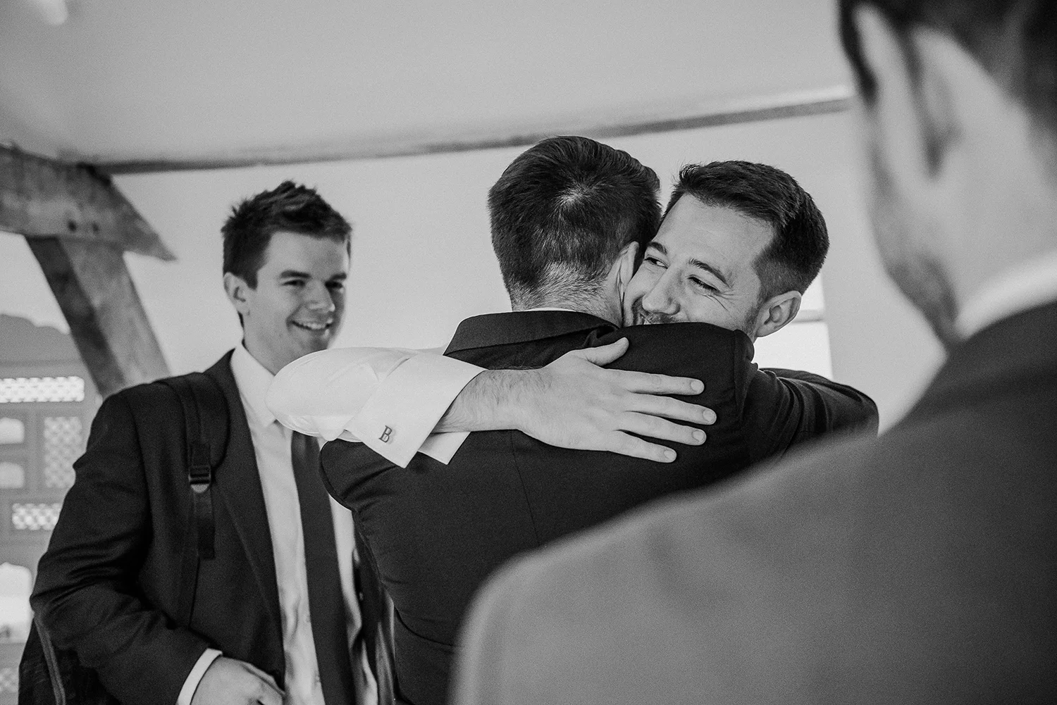 BW photo of the groom hugging his friends