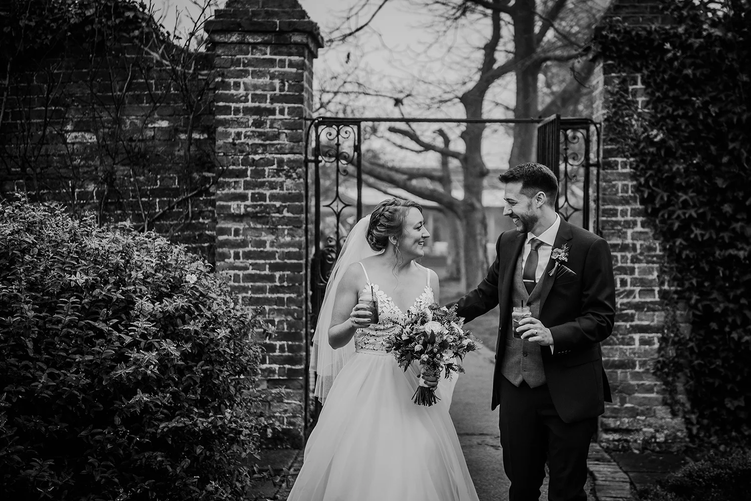BW photo of the couple walking through the gardens