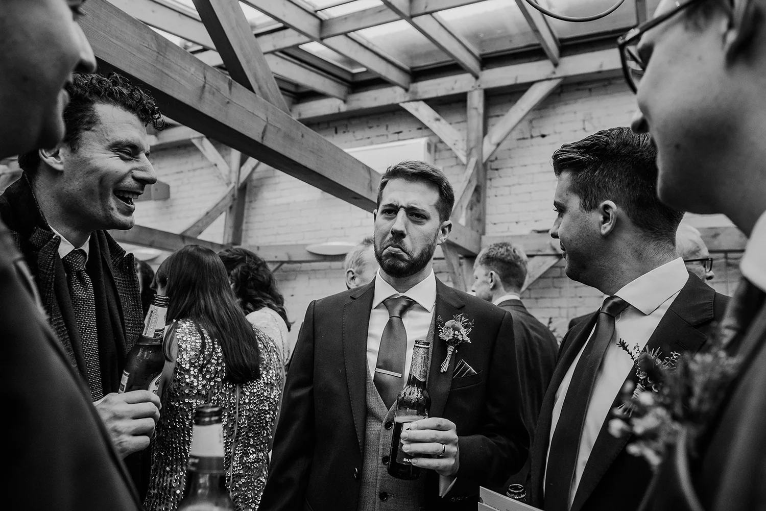 BW photo of the groom having a laugh with his friends