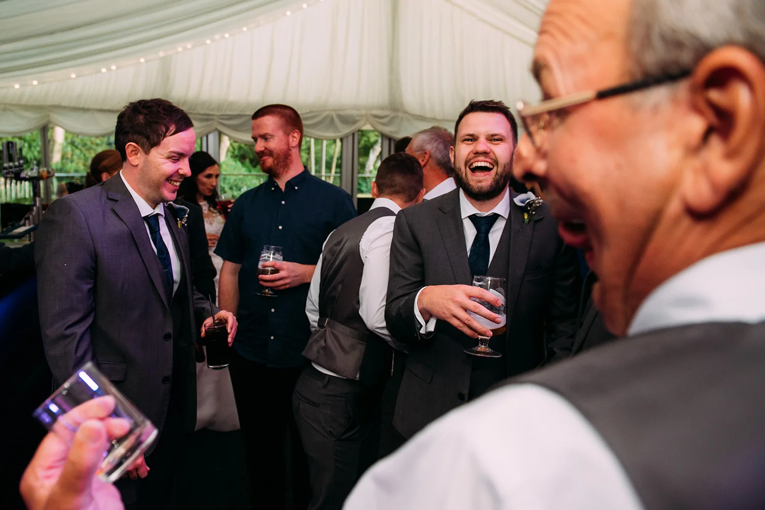 boys laughing at each other after doing a shot