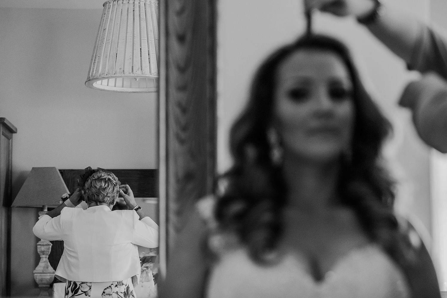 bw split composition. Bride having hair done to the right and mum checking reflection to the left