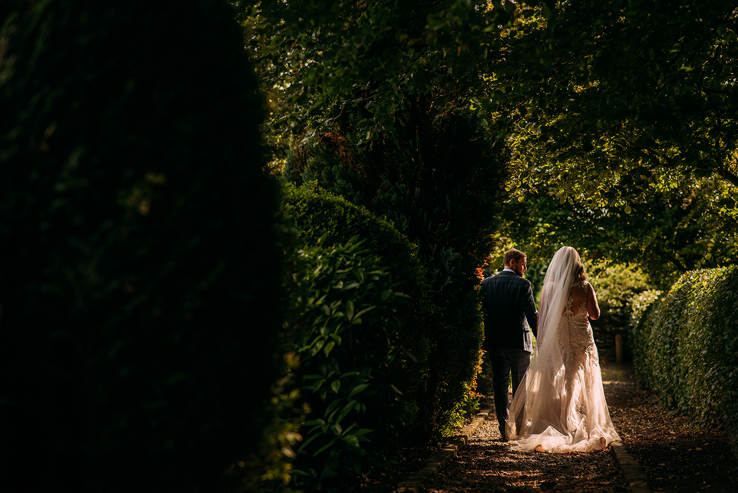 bride and groom walking through the gardens