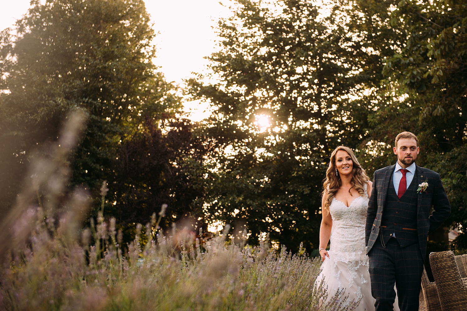 bride and groom walk past lavender at the front of falcon manor
