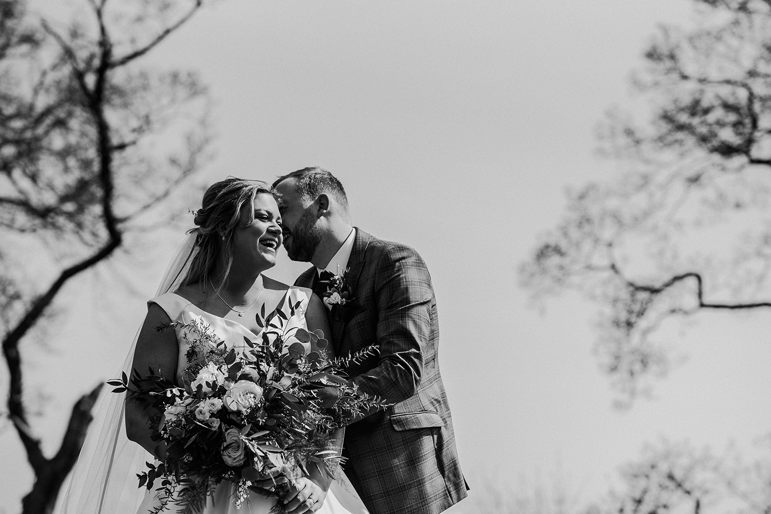 BW photo of the groom kissing the bride