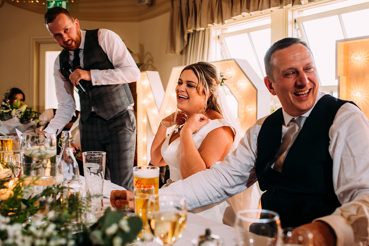 bride and her father laughing during the grooms speech
