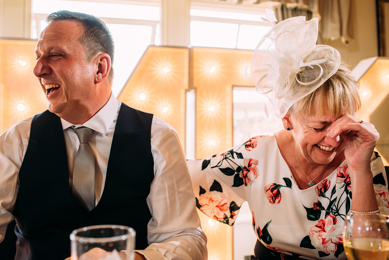 mother of the groom and father of the bride laughing