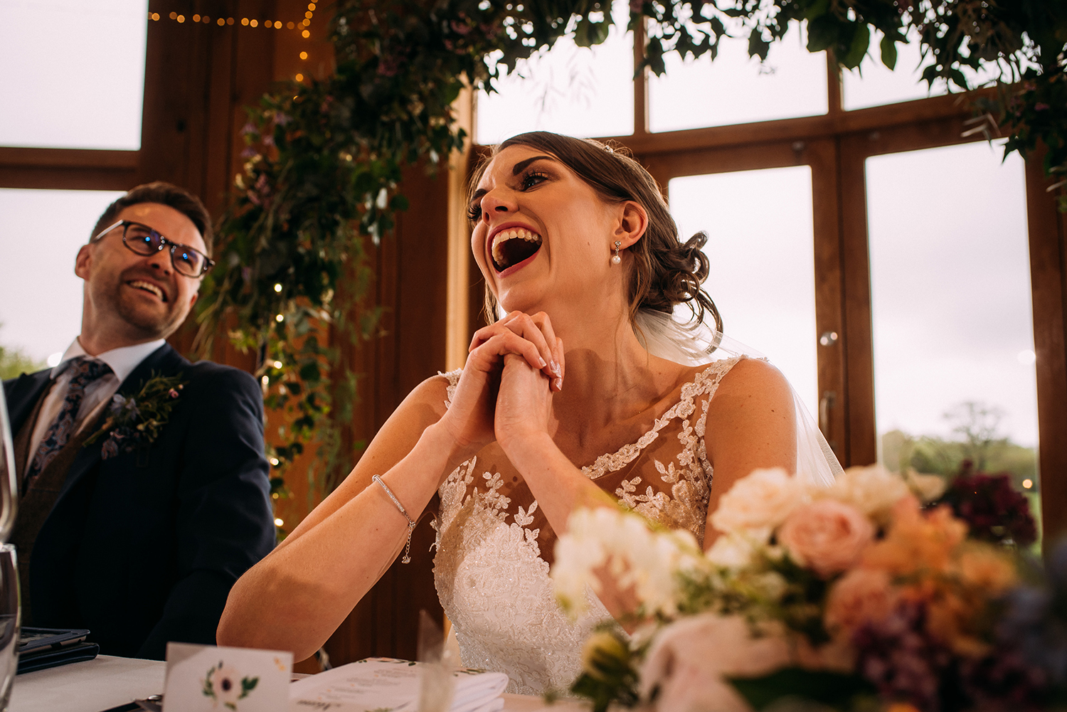Bride and groom laughing during the speeches