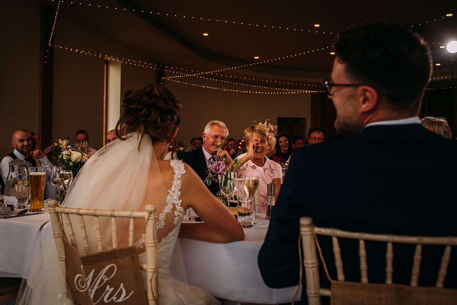 wide shot from behind the bride and groom during the speeches
