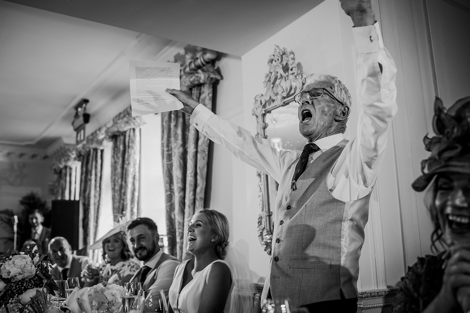 bw photo father of the bride cheers during the speeches