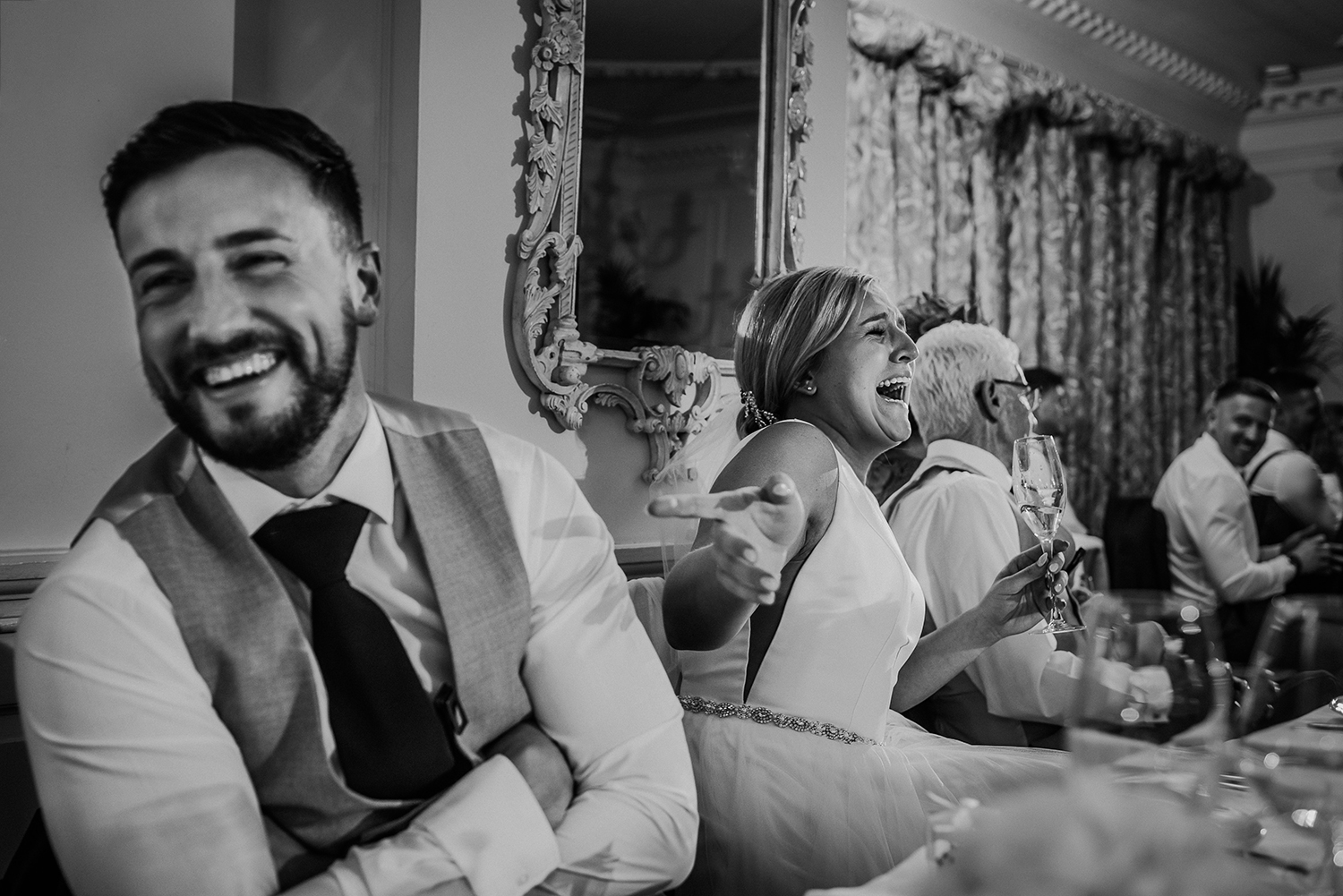 black and white photo of the bride and groom laughing