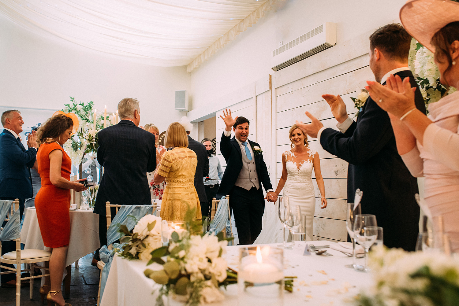bride and groom enter the wedding breakfast at Bashall Barn