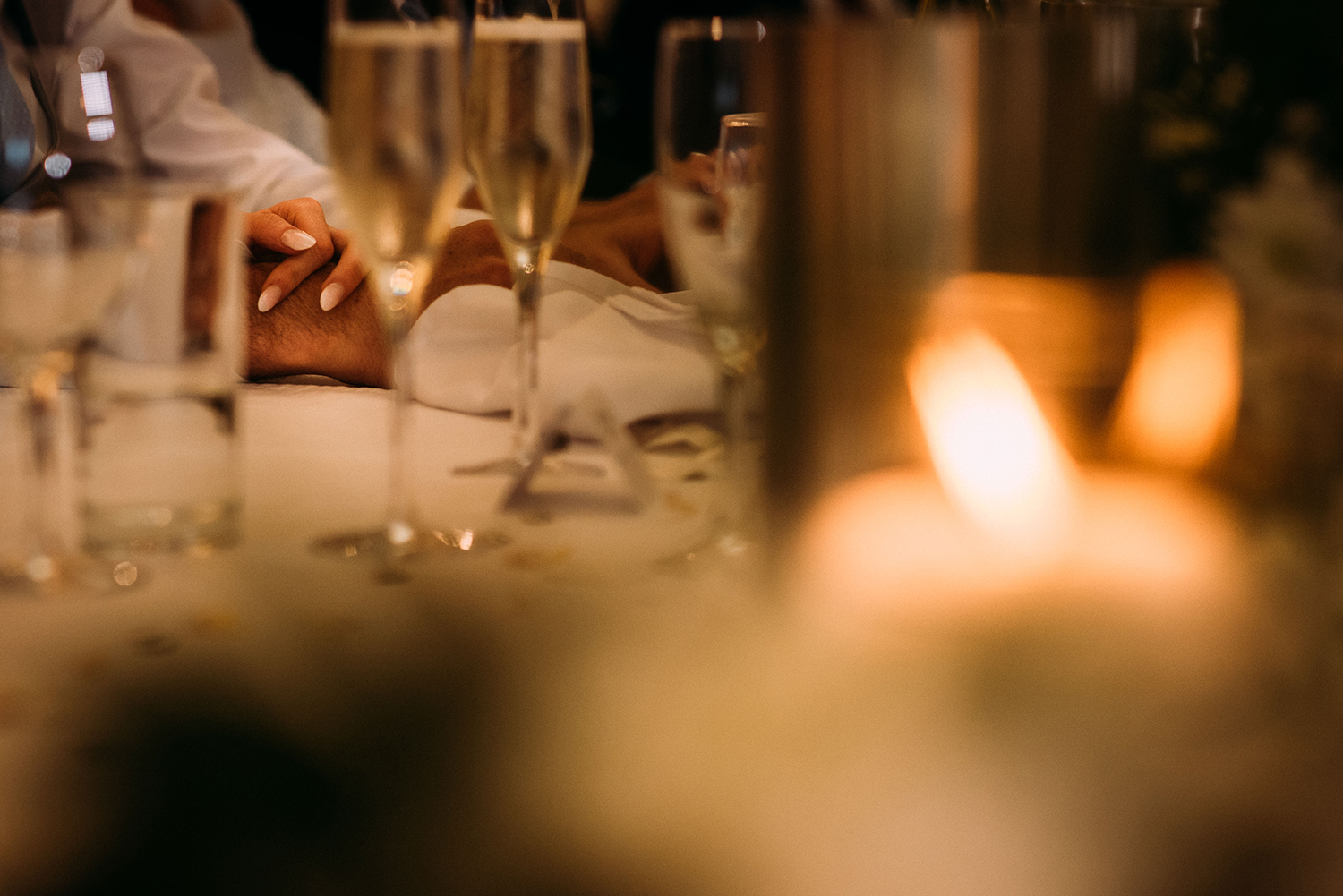 detail of the bride and groom holding hands during the speeches at Bashall Barn