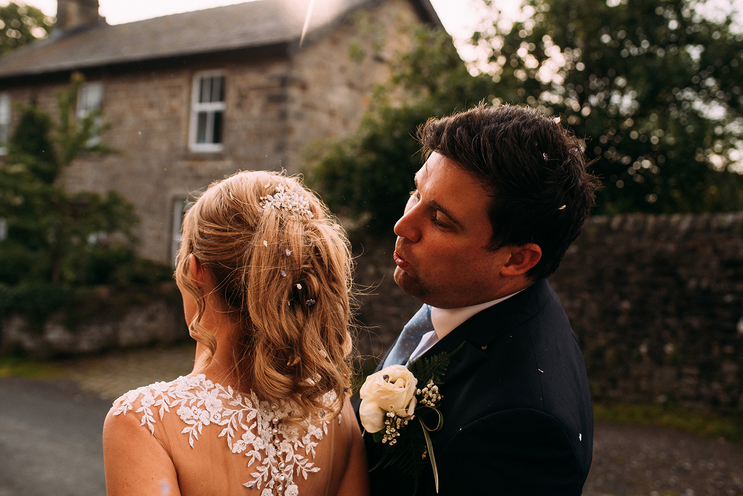 groom picks confetti out of brides hair